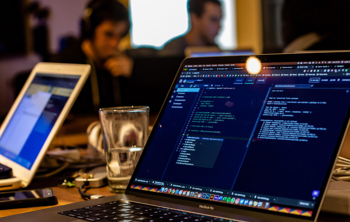 Programming code displayed on laptop screen in office.