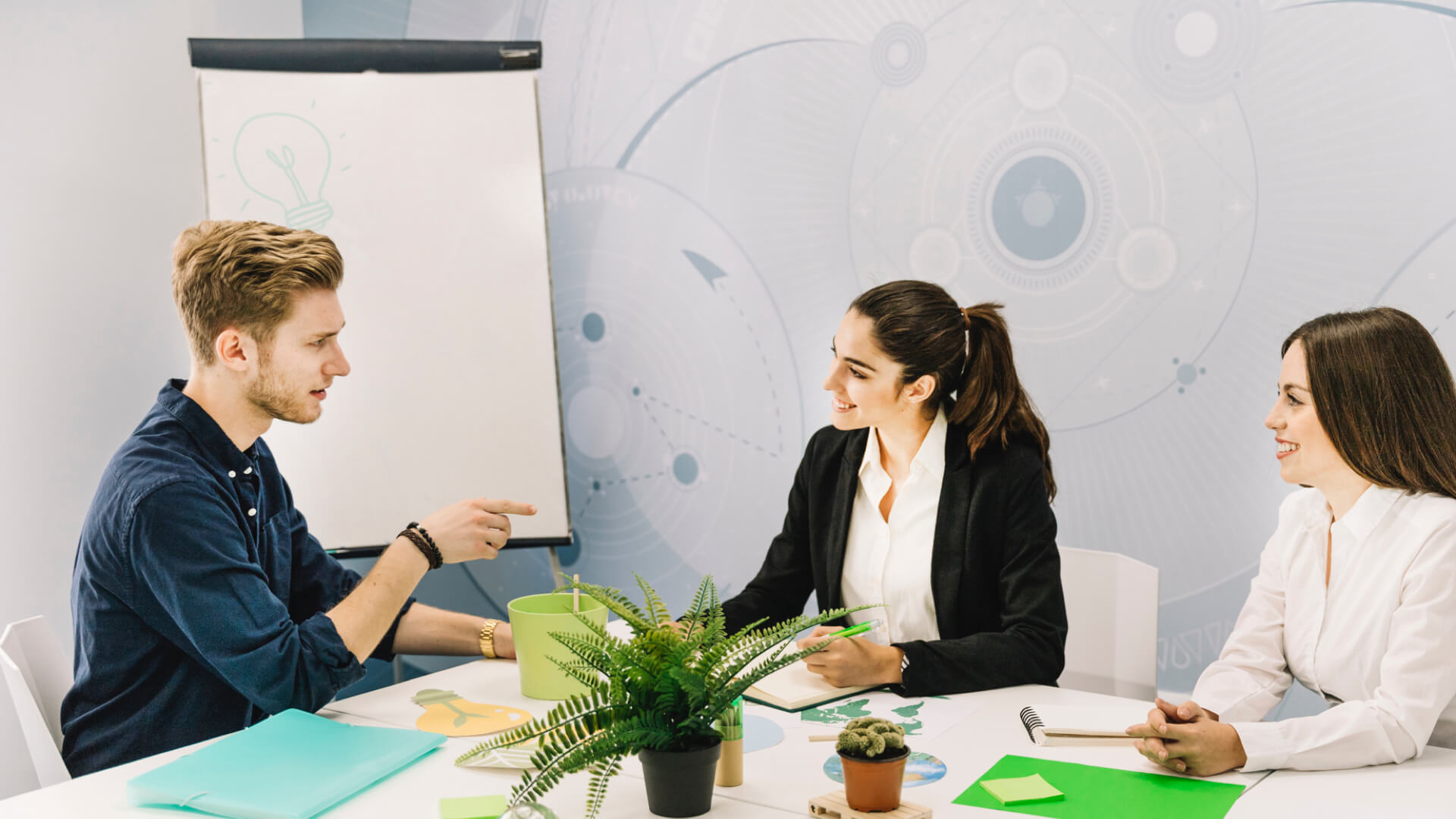 Team meeting with presentation board and plants.
