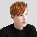 Person wearing black sweater with red hair.
